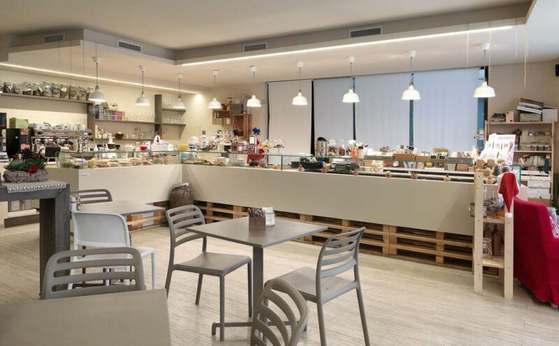 NARDI Costa Bistro Chairs in Taupe with Fiore Tables in Indoor Bakery Cafe