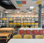 Indoor cafeteria with NARDI Bit Chairs in Coral Red & Mustard Yellow