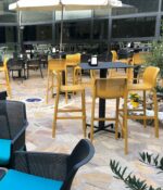 NARDI Net Tall Bar Stools around Bar Leaner in an Outdoor Café Environment in Mustard Yellow