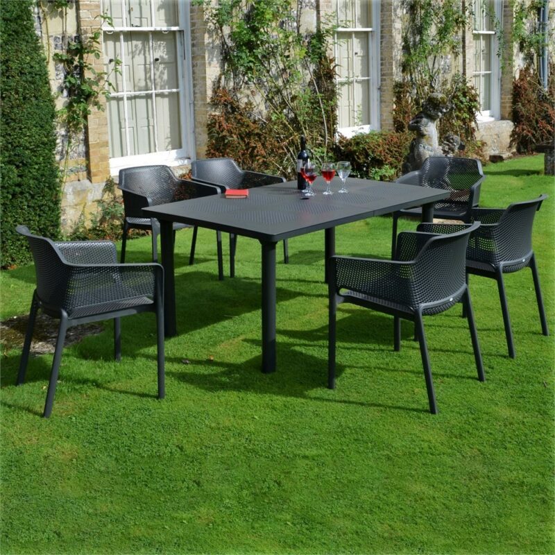 The net levante 7 piece dining set in charcoal pictured outside a country home garden