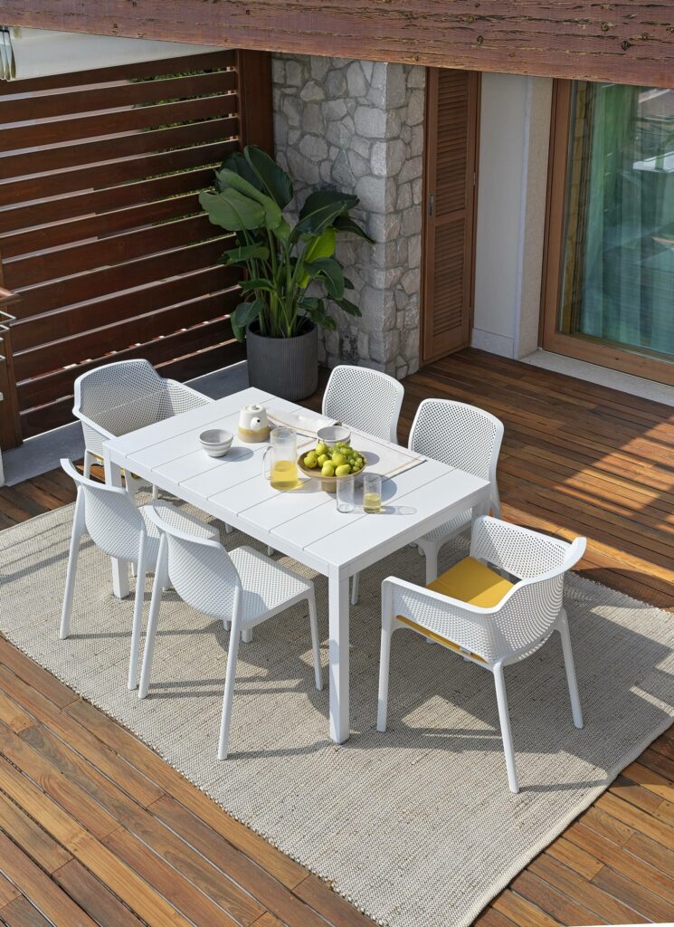 Nardi rio alu 140-210 extendable outdoor dining table with net & bit chairs in white on outdoor deck