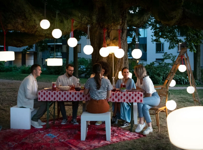 Fatboy® Bolleke Spherical Lamps Hanging over Outdoor Dining Party
